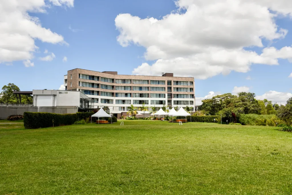 Edificio moderno con jardines verdes y carpas blancas instaladas en el césped, ideal para eventos en Local Smiles.