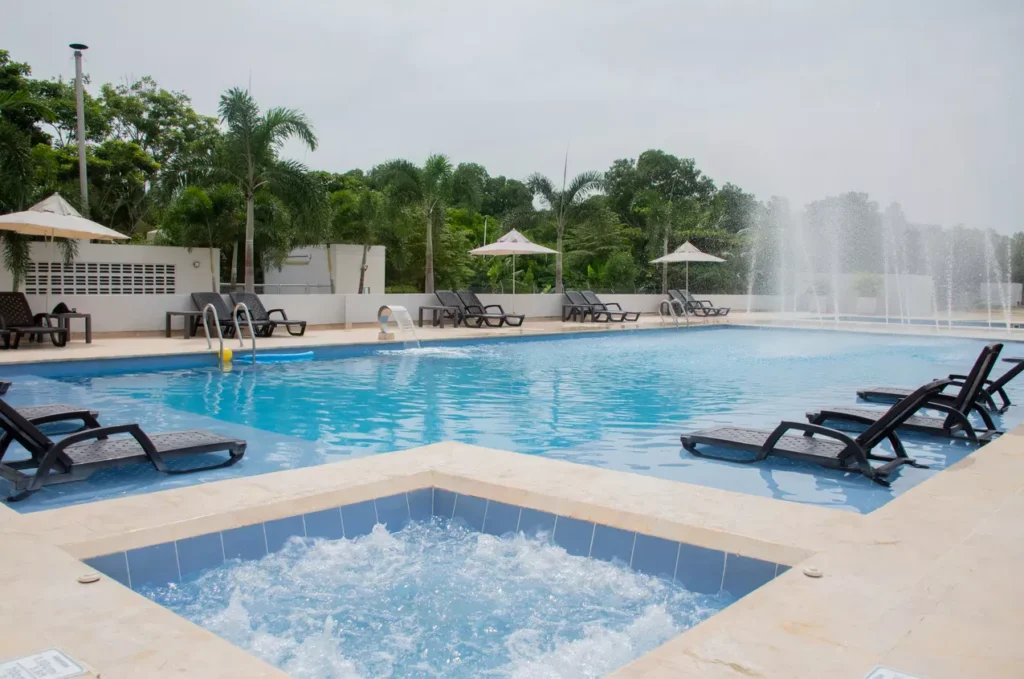 Piscina y jacuzzi del hotel Local Smiles con tumbonas, cascadas y fuentes.